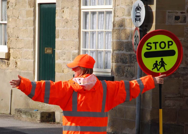 School traffic lady letting kids cross the road