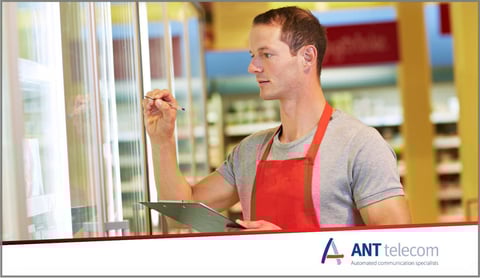 A man recording the temperature of their freezers in a store 