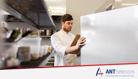 A man recording a fridge's temperature 