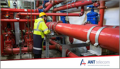 Maintenance engineer carrying out routine inspections in a manufacturing plant room.