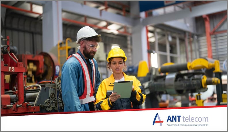 A supervisor discussing tasks with colleague on large manufacturing site 