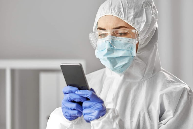 Doctor in medical gear on smartphone