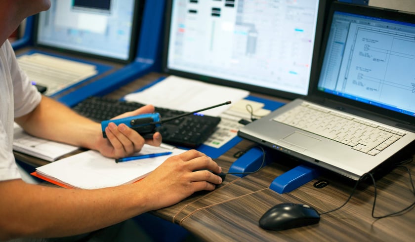 man using radio and laptop at desk