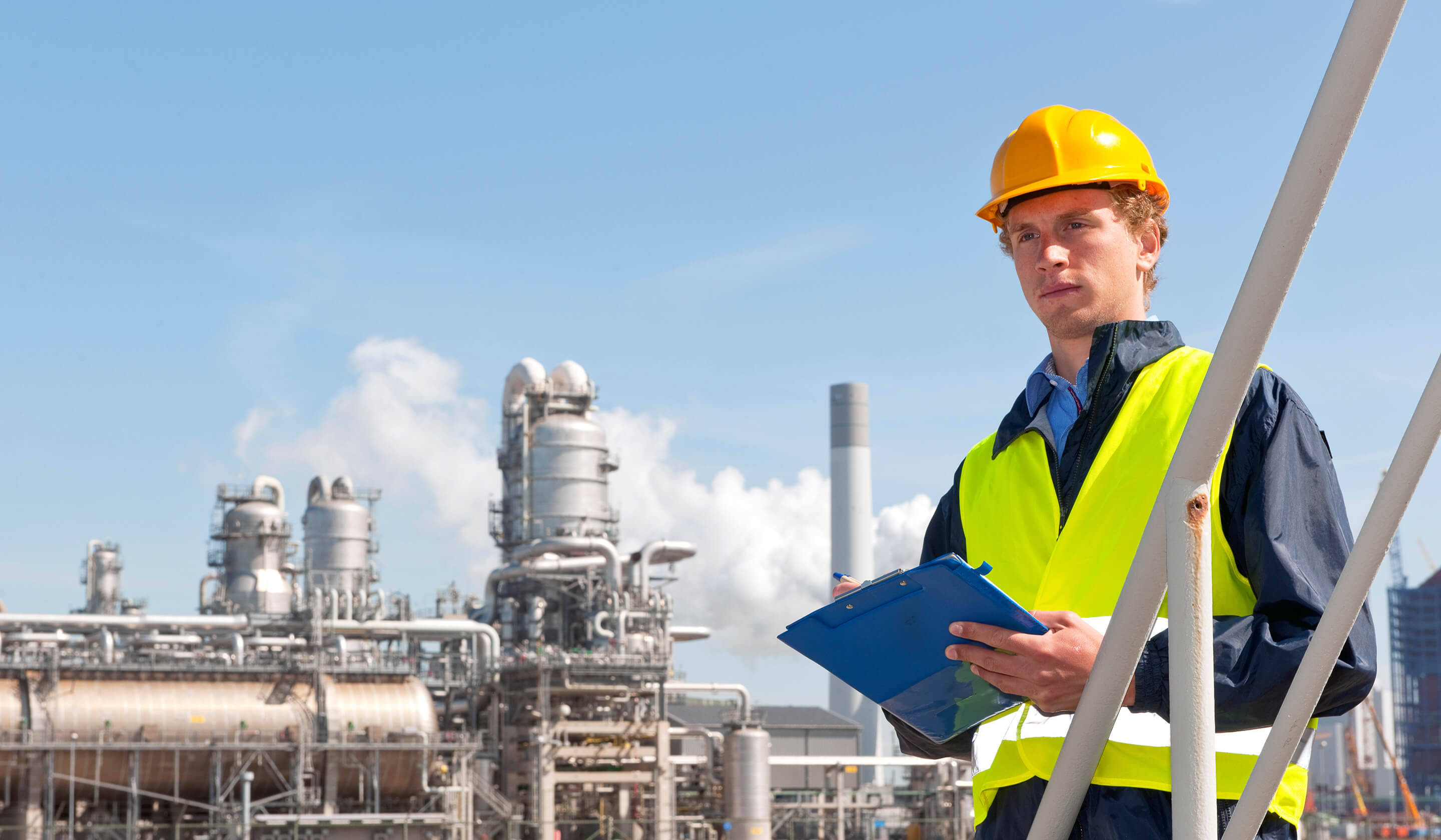 worker wearing an hard hat holding a clipboard